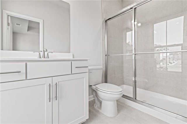 bathroom with tile patterned floors, toilet, vanity, and walk in shower