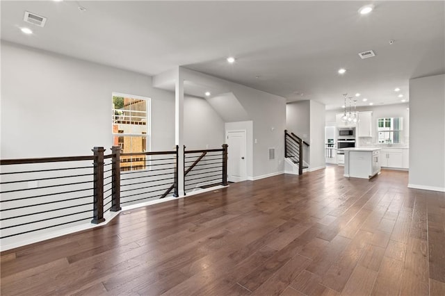 living room with sink, an inviting chandelier, and dark hardwood / wood-style flooring