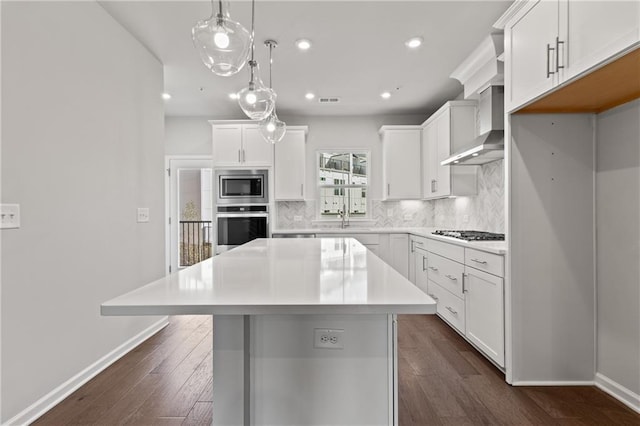 kitchen featuring a center island, decorative backsplash, white cabinets, pendant lighting, and stainless steel appliances