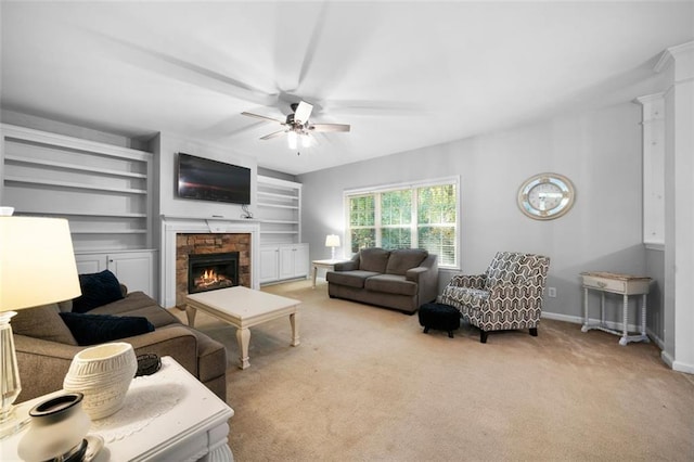 living room with ornate columns, a fireplace, light carpet, and ceiling fan