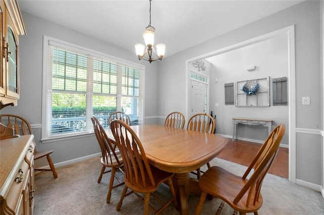 carpeted dining space with a wealth of natural light and a notable chandelier