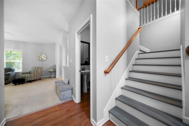 stairway featuring hardwood / wood-style floors and ornate columns