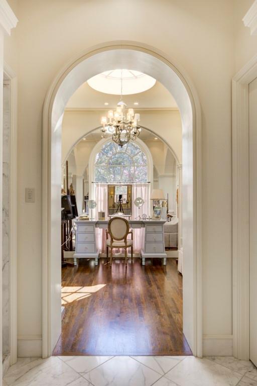 foyer entrance featuring crown molding, hardwood / wood-style floors, and a chandelier