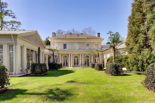 rear view of house featuring a lawn