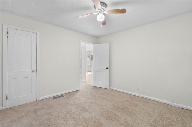 unfurnished room with light carpet and ceiling fan