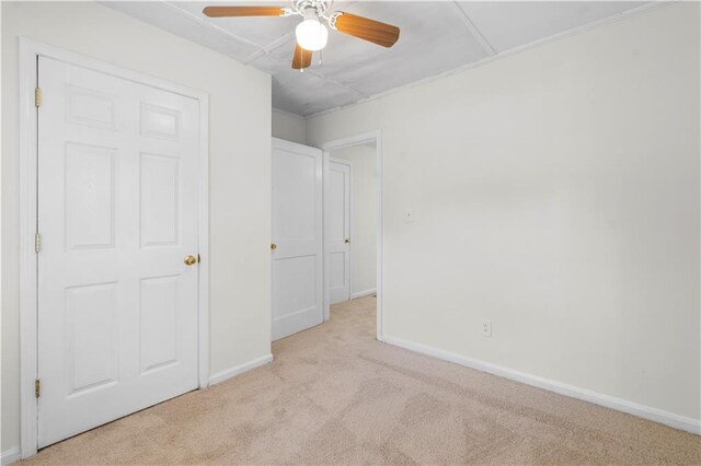 unfurnished bedroom with light colored carpet and ceiling fan