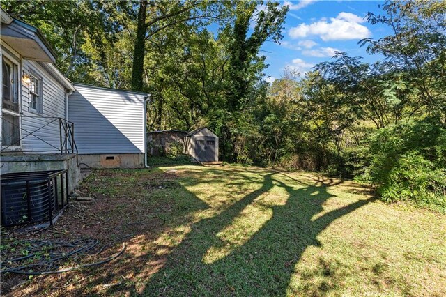 view of yard featuring a storage shed and central AC unit