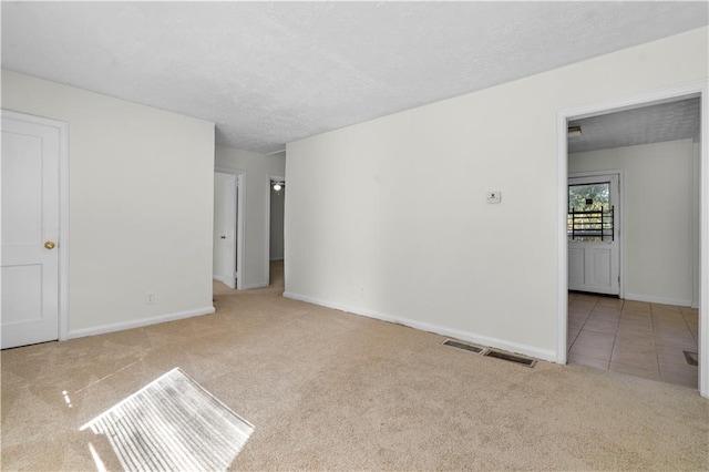 carpeted spare room with a textured ceiling