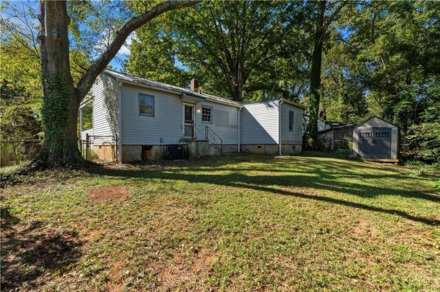 back of house featuring a lawn and central AC unit