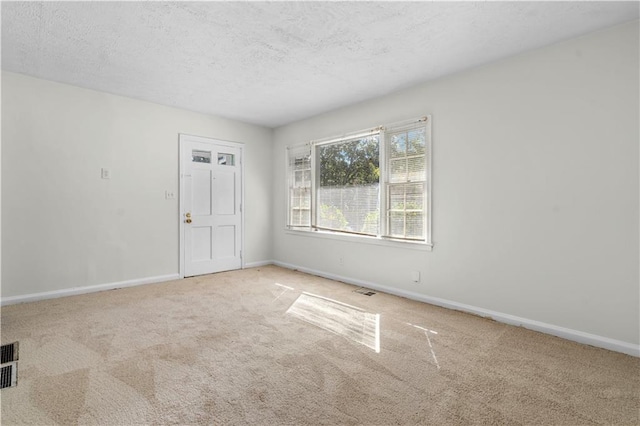 carpeted spare room with a textured ceiling