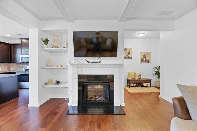 living room with beam ceiling, ornamental molding, and hardwood / wood-style flooring