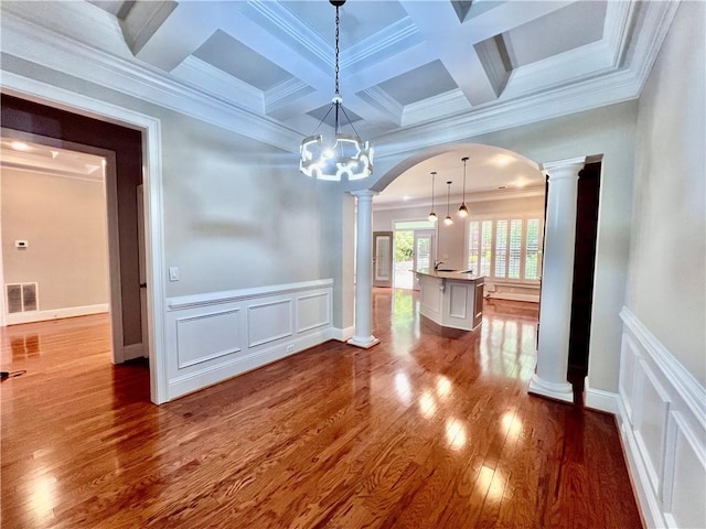 unfurnished dining area with decorative columns, beamed ceiling, hardwood / wood-style flooring, ornamental molding, and coffered ceiling