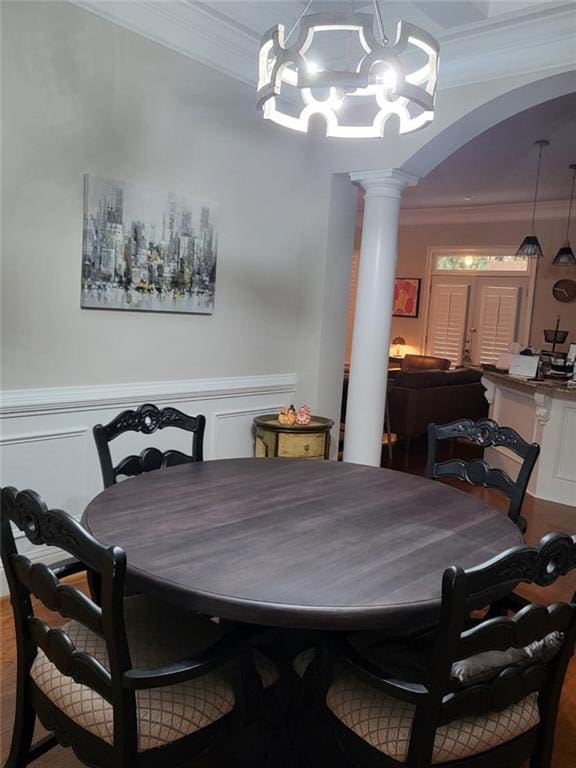 dining room featuring decorative columns, ornamental molding, and wood-type flooring