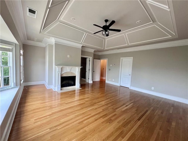 unfurnished living room with ceiling fan, a high end fireplace, wood-type flooring, and ornamental molding