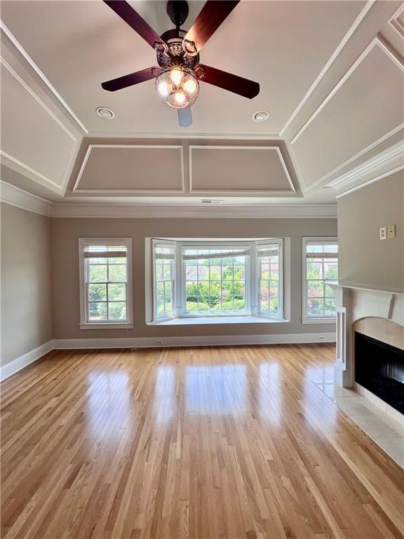 unfurnished living room featuring ornamental molding, light wood-type flooring, and plenty of natural light