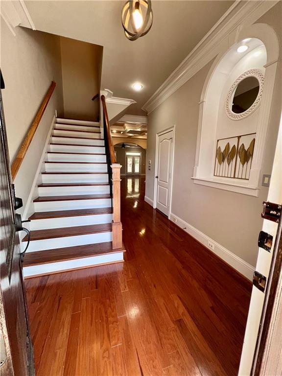 stairway featuring hardwood / wood-style floors and crown molding