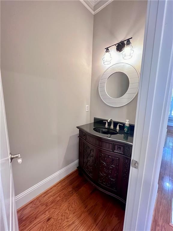 bathroom with hardwood / wood-style flooring, vanity, and ornamental molding