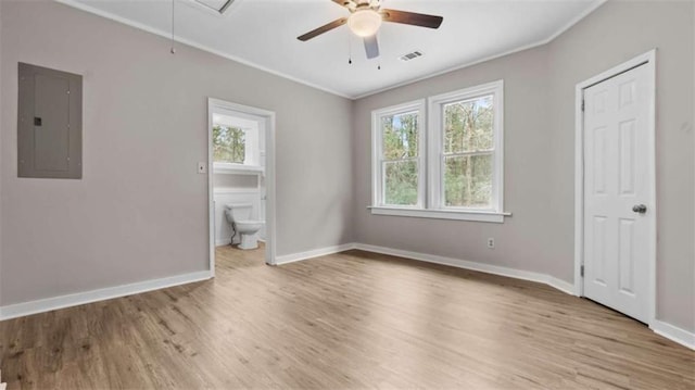 unfurnished bedroom with ornamental molding, electric panel, light hardwood / wood-style floors, and multiple windows