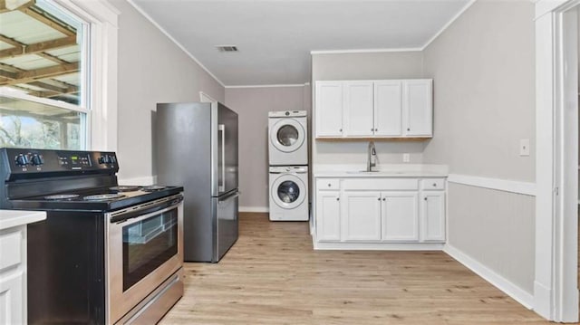 kitchen with white cabinetry, sink, stacked washer and clothes dryer, stainless steel appliances, and crown molding