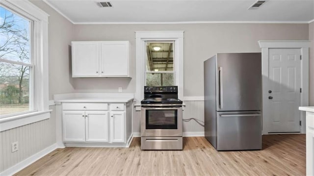 kitchen with stainless steel appliances, a wealth of natural light, light hardwood / wood-style floors, and white cabinets