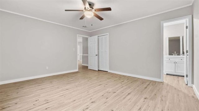 unfurnished bedroom featuring connected bathroom, ornamental molding, ceiling fan, light hardwood / wood-style floors, and a closet