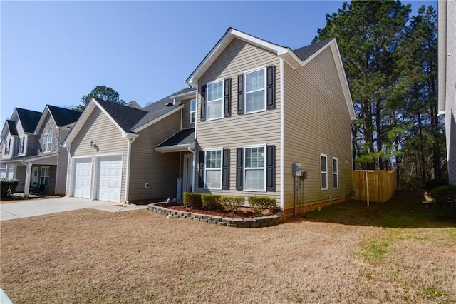 traditional-style house featuring a garage, driveway, a front yard, and fence