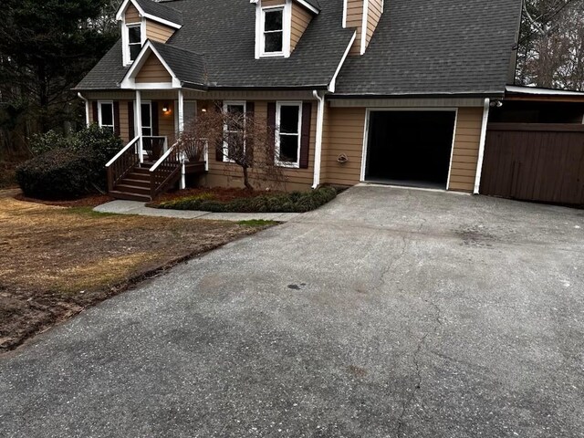 cape cod-style house with a garage and a front yard