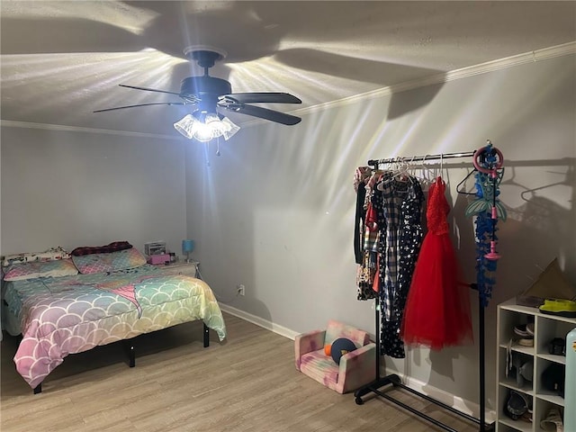 bedroom with ceiling fan, wood finished floors, baseboards, and ornamental molding