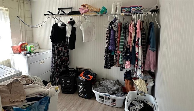 walk in closet with washer and dryer and wood finished floors