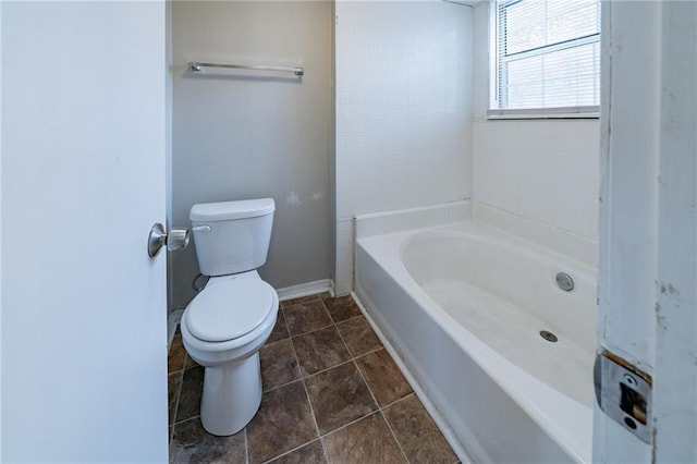 bathroom featuring a bathtub, tile patterned flooring, and toilet