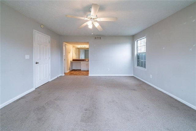 spare room featuring light carpet and ceiling fan