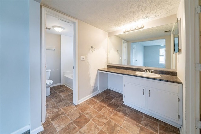 bathroom featuring vanity, a textured ceiling, and toilet