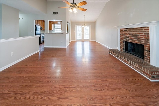 unfurnished living room with a fireplace, hardwood / wood-style floors, and high vaulted ceiling