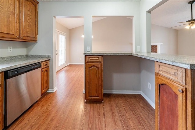 kitchen featuring dishwasher, lofted ceiling, ceiling fan, light hardwood / wood-style floors, and kitchen peninsula