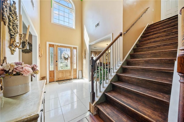 foyer with a high ceiling, plenty of natural light, and tile patterned flooring