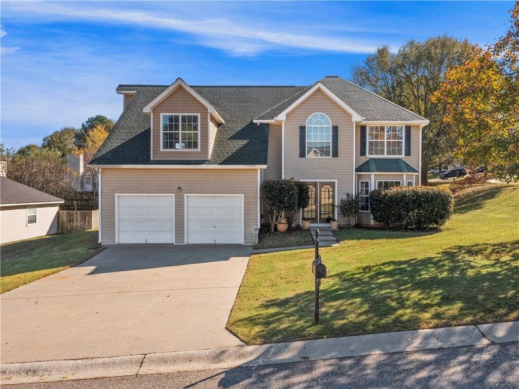 view of front of property with a front yard and a garage