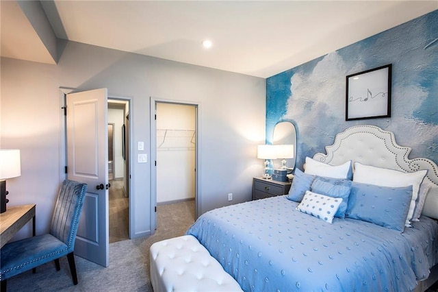 bedroom featuring a walk in closet, a closet, and carpet flooring