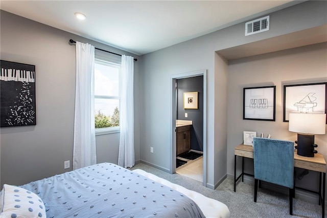 bedroom with light colored carpet and connected bathroom