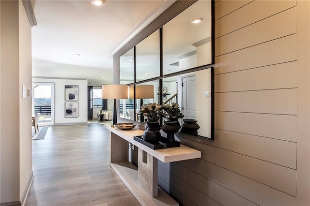 hallway featuring crown molding and light hardwood / wood-style flooring