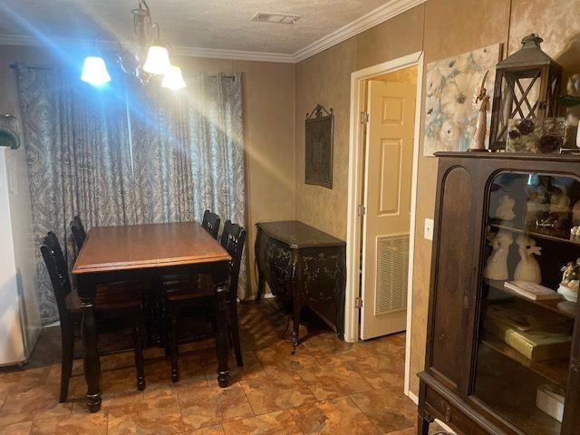 1167 Underwood Rd, Sparta, GA 31087 - dining area with crown molding and a chandelier