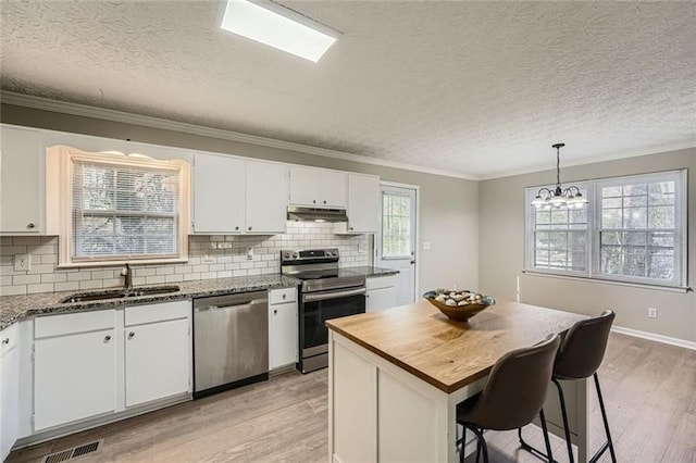 840 Wells Cir SE, Smyrna, GA 30080 - kitchen featuring stainless steel appliances, a sink, under cabinet range hood, light wood-style flooring, and a textured ceiling