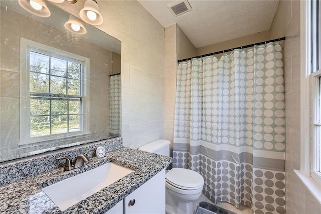 840 Wells Cir SE, Smyrna, GA 30080 - bathroom featuring tile walls, toilet, plenty of natural light, a shower with curtain, and a textured ceiling