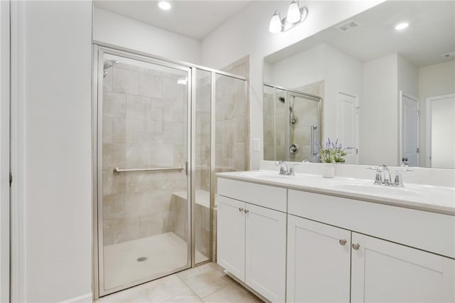 bathroom featuring double vanity, a sink, visible vents, and a shower stall