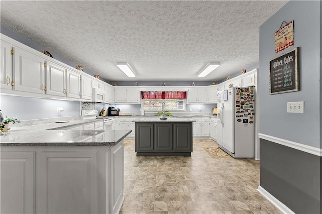 305 Mountain Brook Rd, Dawsonville, GA 30534 - kitchen featuring a peninsula, white cabinetry, light stone counters, and white appliances