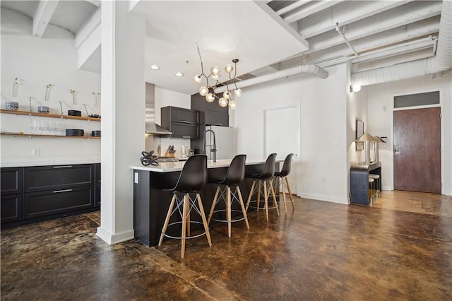 kitchen featuring a kitchen breakfast bar, white fridge, and wall chimney range hood