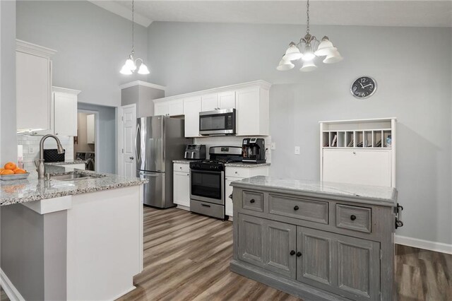 entryway featuring dark wood-type flooring, a chandelier, and vaulted ceiling