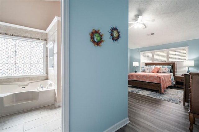 bedroom with multiple windows, hardwood / wood-style flooring, and ceiling fan