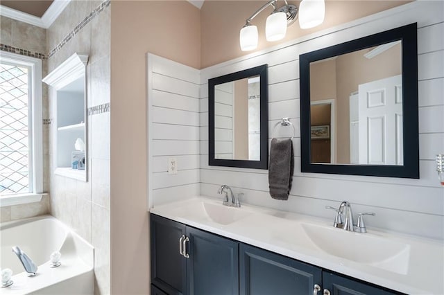 bathroom featuring vanity, a washtub, and crown molding