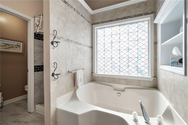 bathroom featuring ornamental molding, a bathing tub, and toilet