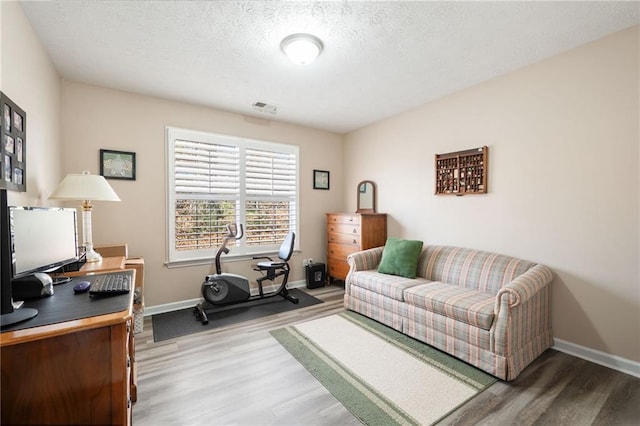 home office featuring hardwood / wood-style floors and a textured ceiling